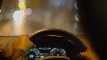 kvinna person med svart lockigt hår körning bil i de stad på natt trafik video