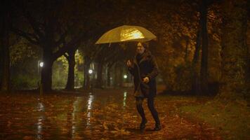 content insouciant femme dansant avec parapluie à l'extérieur dans pluvieux nuit video