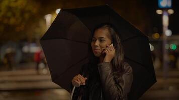 feliz fêmea pessoa chamando conversando usando inteligente telefone caminhando em urbano rua video