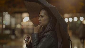 pensativo jovem mulher pensando sobre vida lado de fora dentro a chuva às noite video