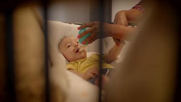 mor matning ung bebis spädbarn barn liggande i spjälsäng på Hem video