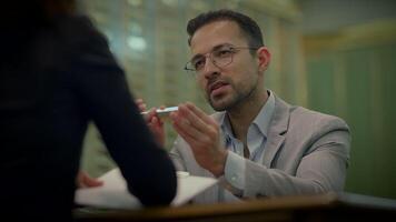 a man is sitting at a table talking to a woman video