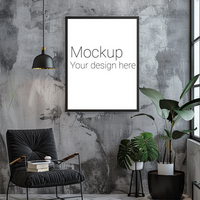 Mockup of black frame for poster or photo on gray living room wall above chair next to potted flower psd