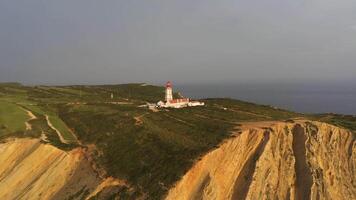 cabo epichel i portugal på solnedgång. klippor, fyr och atlanten hav. gyllene timme. antenn se. kretsande video