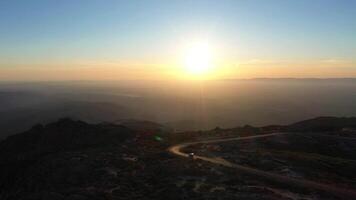 coche en la carretera en serra da estrela montañas a puesta de sol. Portugal. aéreo vista. zumbido se mueve adelante y hacia arriba video