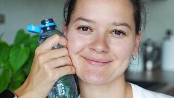 joven mujer con botella con estacionario el plastico gorra. el nuevo diseño medio el gorra permanece adjunto a el botella después apertura, haciendo el todo paquete más fácil a recoger y reciclar. video