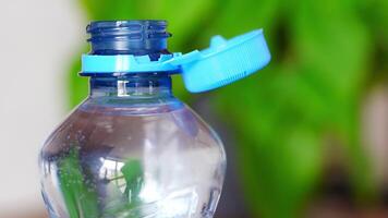 Stationary plastic cap on a PET bottle. The new design means the cap remains attached to the bottle after opening, making the entire package easier to collect and recycle. High quality 4k footage video