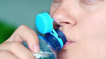 Young woman drinking from a bottle with stationary plastic cap. The new design means the cap remains attached to the bottle after opening, making the entire package easier to collect and recycle. video