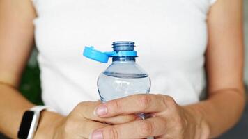 Bottle with stationary plastic cap in woman hand. The new design means the cap remains attached to the bottle after opening, making the entire package easier to collect and recycle. 4k footage video