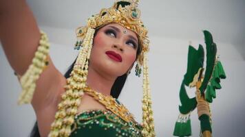 Traditional Balinese dancer in ornate costume and makeup, looking contemplative. video