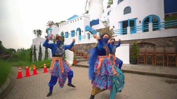 traditioneel dansers in kleurrijk kostuums het uitvoeren van in voorkant van een gebouw met Europese stijl architectuur video
