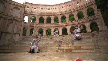 intérpretes en tradicional disfraces bailando en el pasos de un antiguo anfiteatro, exhibiendo cultural patrimonio y artístico expresión. video
