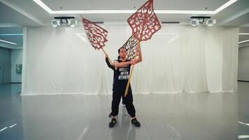 três homens praticando tradicional dança com ampla ornamentado adereços dentro uma estúdio contexto, exibindo cultural desempenho artes. video