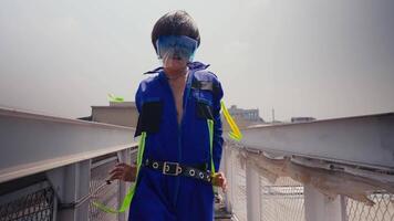 Person in futuristic outfit with VR headset standing on an urban bridge, concept of virtual reality video