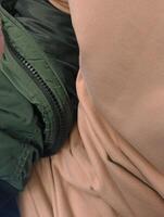 Close-up of a man's waist in a green jacket. photo