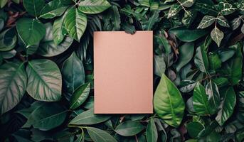 Square Paper Surrounded by Green Leaves photo