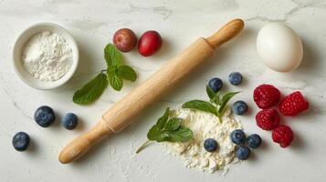 Wooden Rolling Pin Surrounded by Berries, Eggs, and Ingredients photo