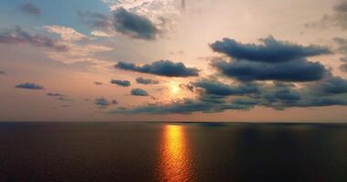 Aerial drone view of clear turquoise sea and waves over the ocean with sunset video