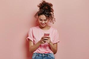 Woman in Pink Shirt Looking at Cell Phone photo