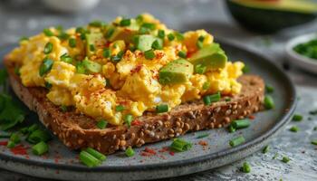 revuelto huevos en brindis con aguacate y cebollín foto