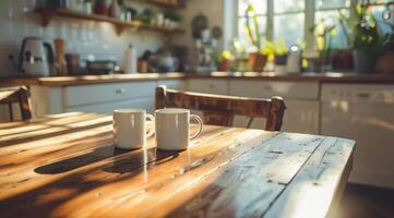 Two Mugs on a Wooden Table in a Kitchen photo