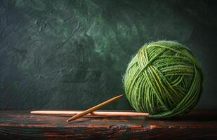 Green Yarn Ball and Knitting Needles on Wooden Table photo