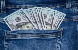 One hundred dollar banknote money in pocket jeans pants background texture. 100 dollar bill close up 1 photo