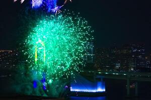 un noche fuegos artificiales cerca arco iris puente a el urbano ciudad en tokio largo Disparo foto