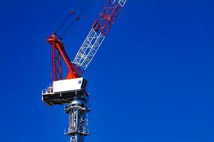 Moving cranes behind the blue sky at the under construction in Tokyo photo