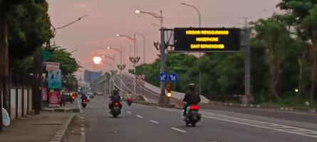 The atmosphere of a highway in the city with motorbikes and cars photo