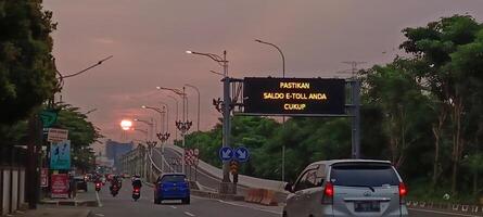 The atmosphere of a highway in the city with motorbikes and cars photo