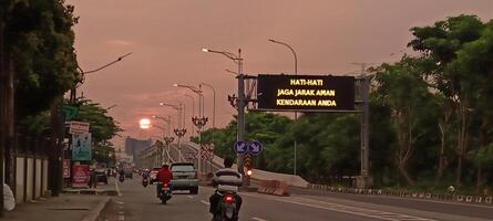 The atmosphere of a highway in the city with motorbikes and cars photo