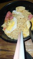 Noodles with egg and sausage with spoon and chopsticks photo