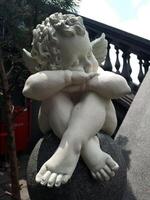 Statue of cute angel on the stairs photo