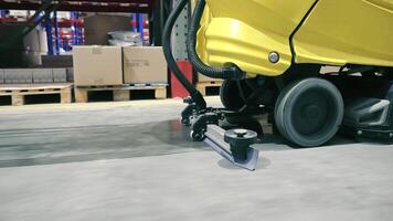 Industrial floor cleaning machine in warehouse, A detailed shot of an industrial floor cleaning machine operating in a warehouse environment video