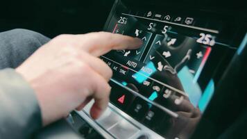 de man kontroller de klimat och interiör av de bil. de finger växlar de parametrar av de sensor klimat kontrollera i de bil. video
