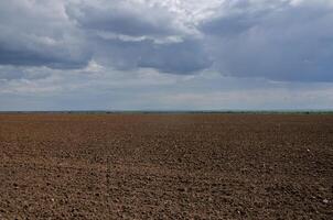 A ploughed field for planting, a dark sky with light gaps. minimalism photo