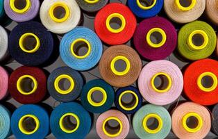 set of multi-colored spools of thread for sewing photo