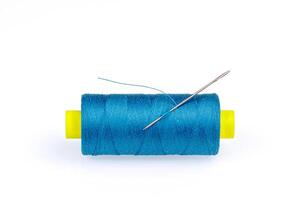 Macro skein of blue thread with a needle on a white background photo