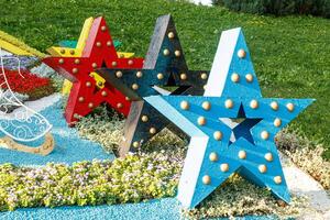 sculptures of multi-colored stars on a background of grass photo