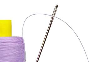 Macro skein of thread purple colors with a needle on a white background photo