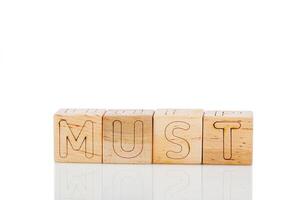 Wooden cubes with letters must on a white background photo