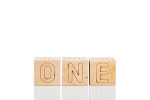 Wooden cubes with letters one on a white background photo