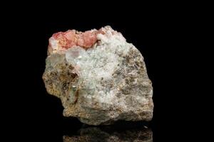 Macro of the mineral stone Rhodochrosite with fluorite on a black background photo