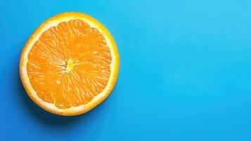 A juicy half-sliced orange on a bold blue background, bursting with color photo