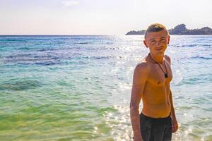 Happy man in water and on paradise tropical beach Maldives. photo