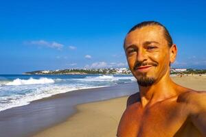 Selfie with rocks cliffs view waves beach Puerto Escondido Mexico. photo