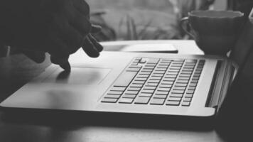 Business person types on a laptop keyboard. Type background. Modern office worker using a laptop, typing a text black and white footage video