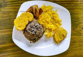 costa rico comida plato arroz plátano revuelto huevos frijoles un pan. foto