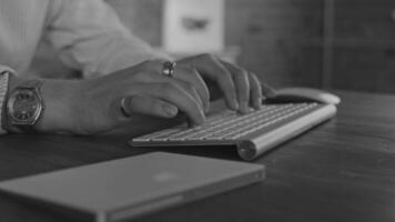 Business person types on a laptop keyboard. Type background. Modern office worker using a laptop, typing a text black and white footage video